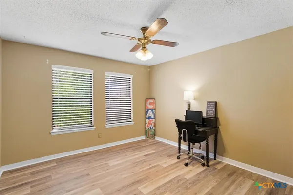 a view of a workspace with furniture and a window