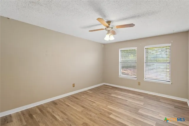 a view of an empty room with a window and closet area