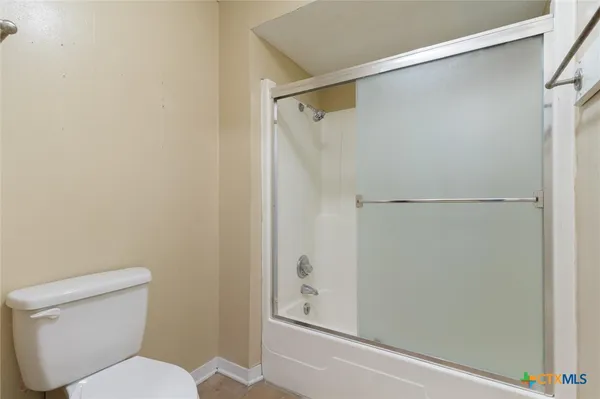 a white toilet sitting next to a shower
