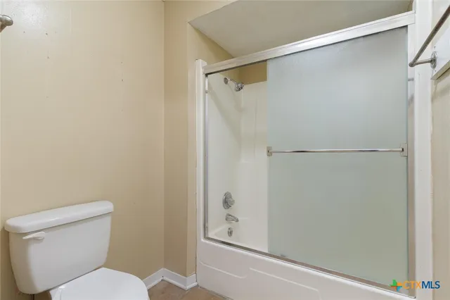a white toilet sitting next to a shower