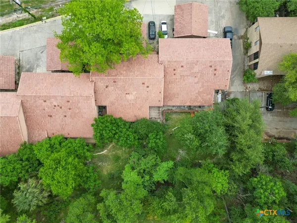 an aerial view of a residential apartment building with a yard and lake view
