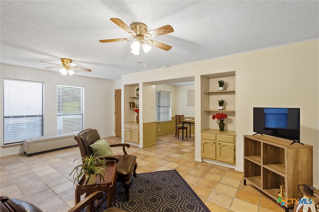 821 Ranch Road 12 San Marcos, TX 78666 - Photo 2 of 30 a living room with furniture a flat screen tv and kitchen view