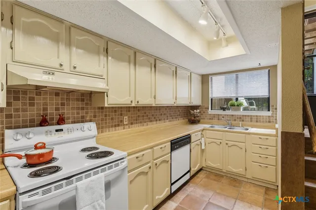 a kitchen with a stove sink and cabinets