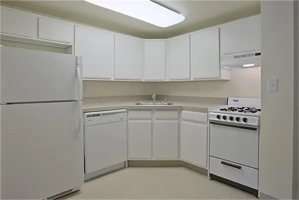 a kitchen with white cabinets and white appliances