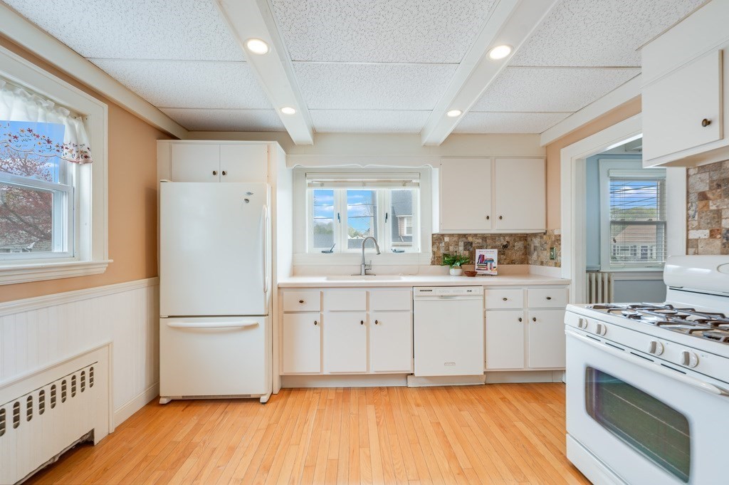 44 Jasper Street Saugus, MA 01906 - Photo 13 of 32 a kitchen with a refrigerator a stove top oven and white cabinets