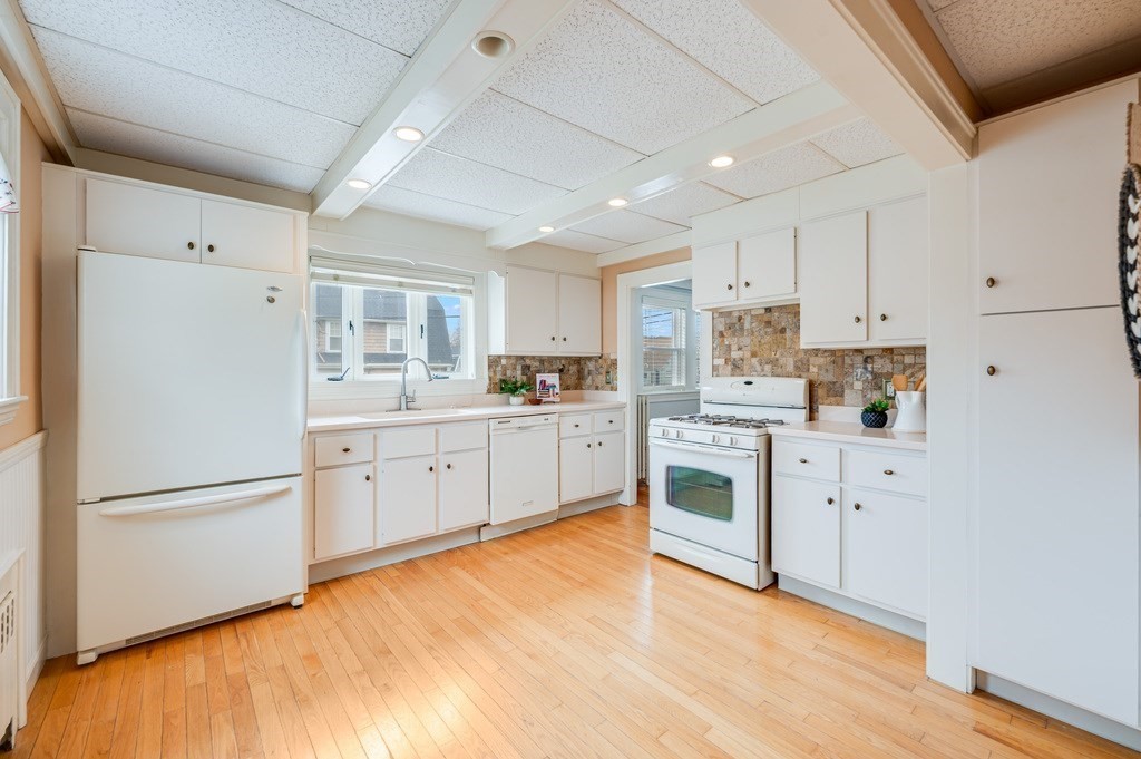 44 Jasper Street Saugus, MA 01906 - Photo 14 of 32 a kitchen with white cabinets and white appliances