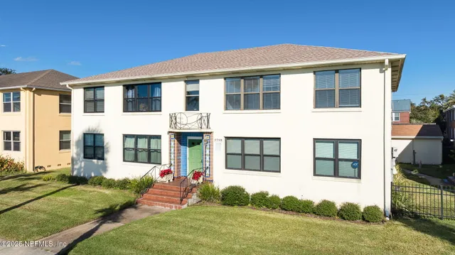 an aerial view of residential houses with outdoor space and street view
