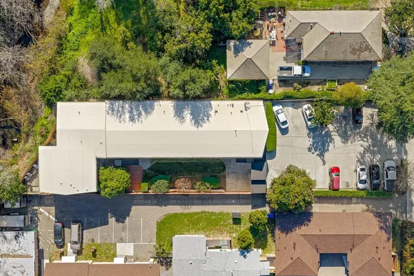 an aerial view of a house with swimming pool and large trees