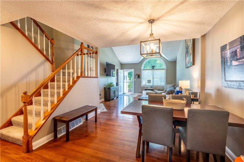 228 Country View Drive Lower Burrell, PA 15068 - Photo 7 of 49 a dining room with wooden floor a chandelier a wooden table and chairs