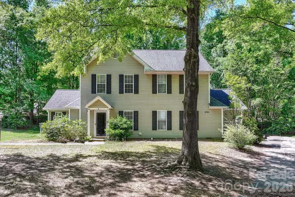 a front view of a house with a yard and trees