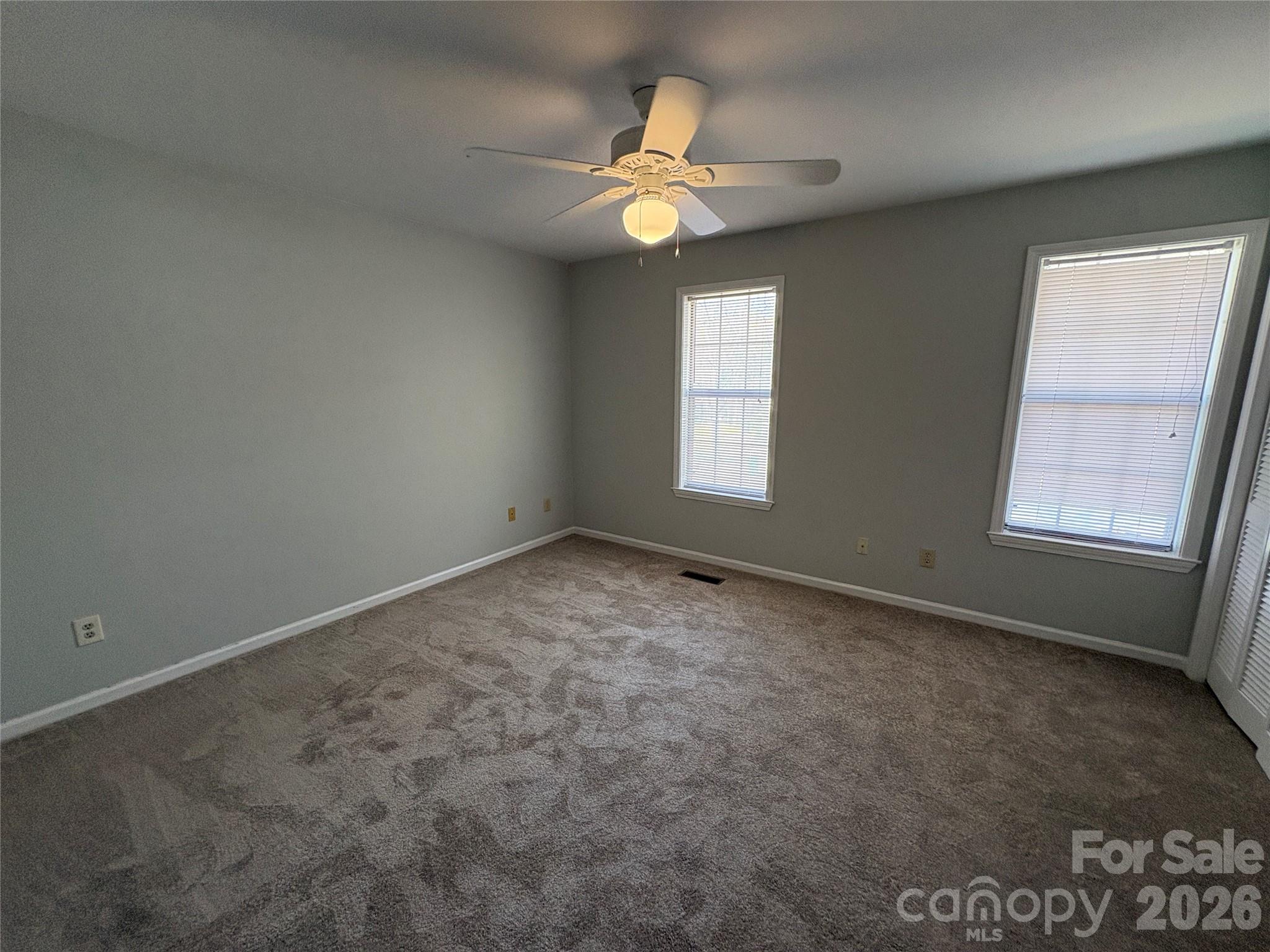 6725 Bevington Ridge Road, Unit A/B Charlotte, NC 28277 - Photo 41 of 48 an empty room with windows and chandelier fan