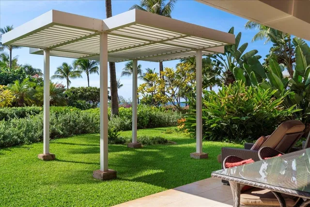 a view of a patio with a table and chairs under an umbrella