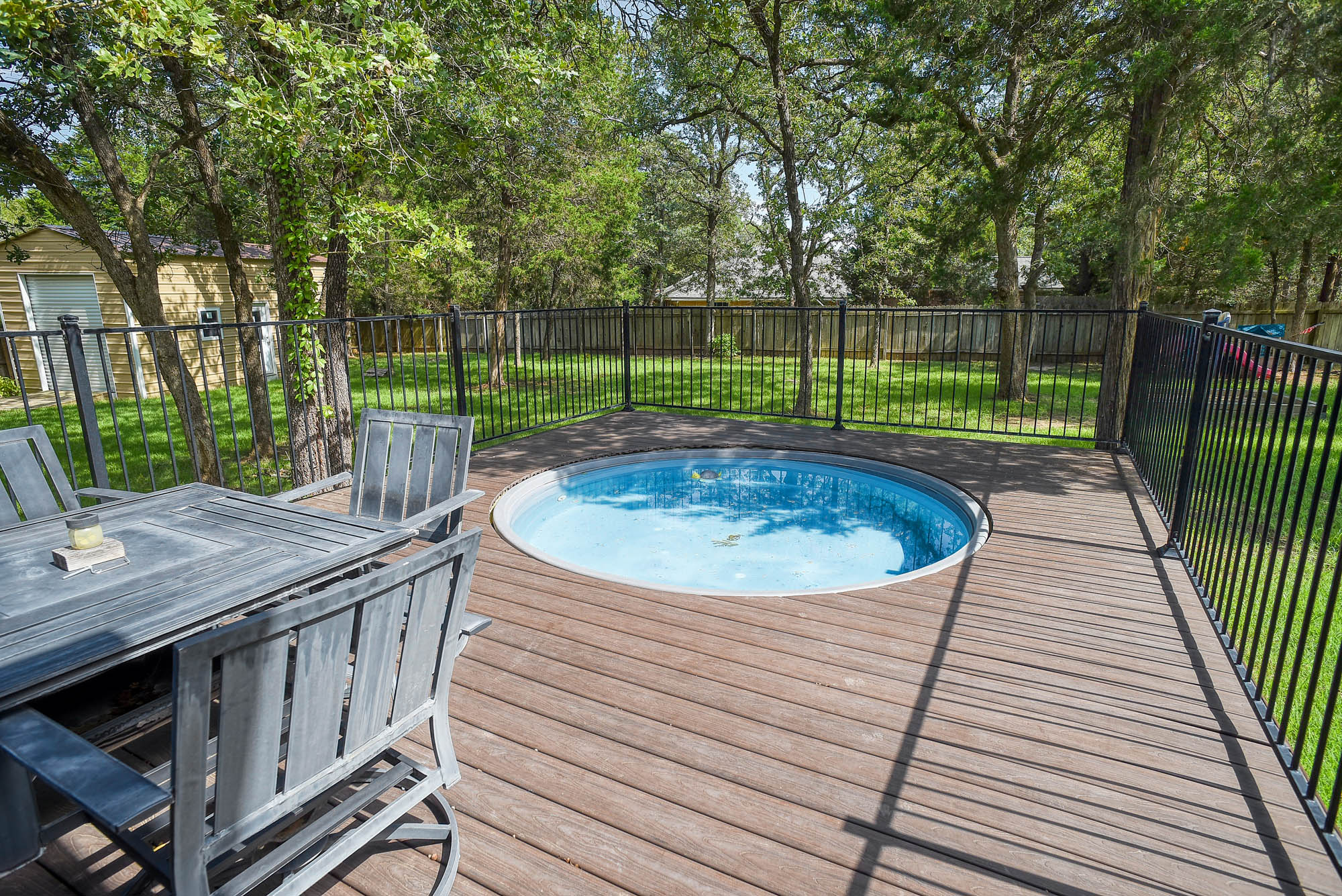 115 Pine Point Cove Elgin, TX 78621 - Photo 33 of 39 A private deck with a built-in cowboy pool creates an inviting outdoor retreat.