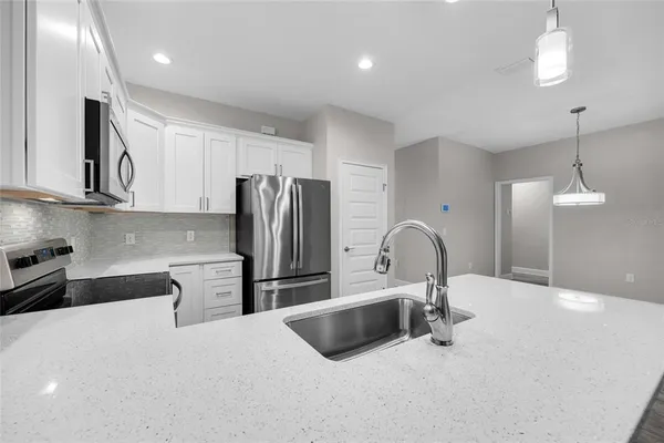 a kitchen with stainless steel appliances a sink a stove a refrigerator and cabinets