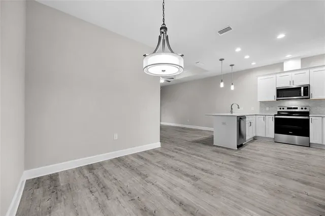 a view of kitchen with sink microwave and stove top oven