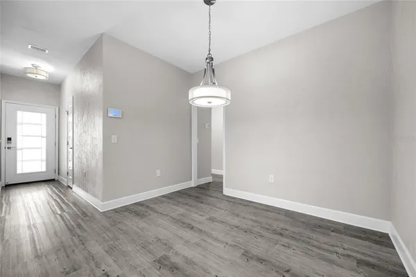 a view of a room with wooden floor staircase and a kitchen