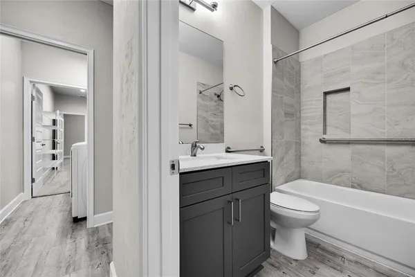 a bathroom with a sink a toilet and shower