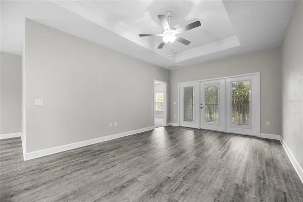 a view of an empty room with a window and wooden floor