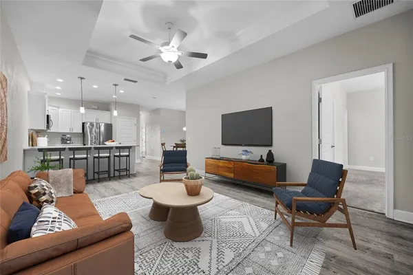 a living room with furniture kitchen view and a flat screen tv