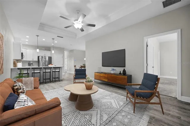 a living room with furniture kitchen view and a flat screen tv