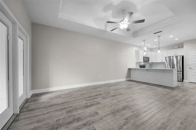 a view of a livingroom with a ceiling fan and wooden floor