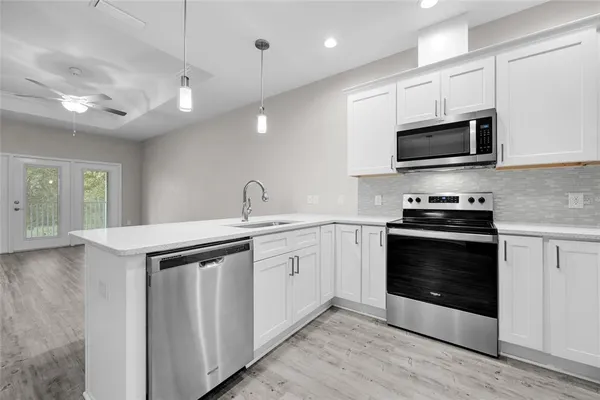 a kitchen with stainless steel appliances a stove microwave and sink