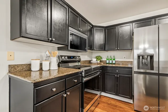 a kitchen with granite countertop stainless steel appliances and wooden cabinets