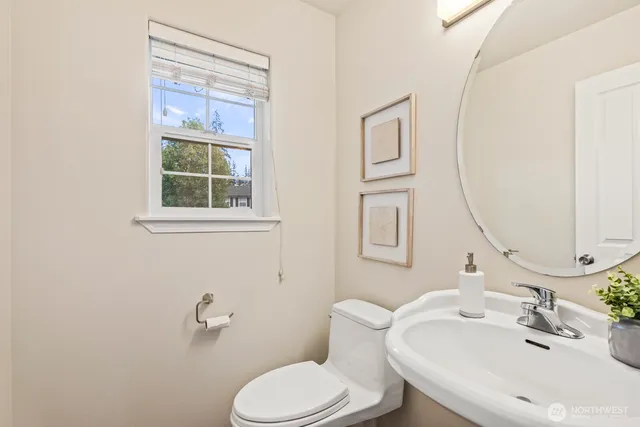 a bathroom with a toilet a sink and mirror