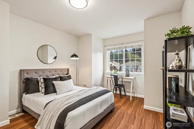 a bedroom with a bed and wooden floor