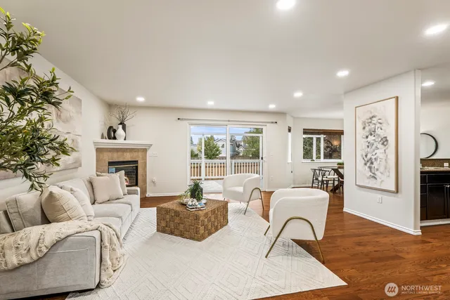 a living room with furniture a fireplace and large windows