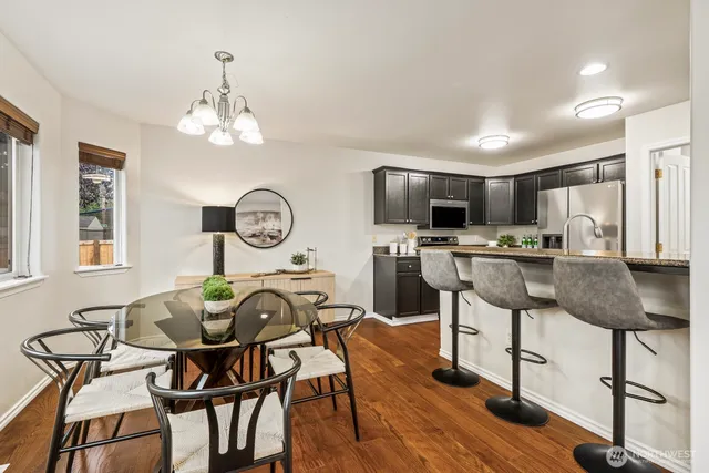 a view of a dining room with furniture a chandelier and wooden floor