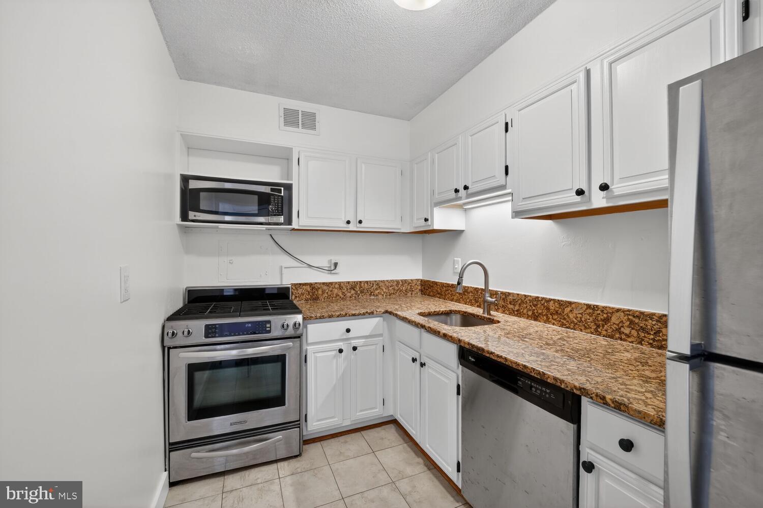240 M Street Southwest, Unit E406 Washington, DC 20024 - Photo 12 of 38 a kitchen with granite countertop cabinets stainless steel appliances and a sink