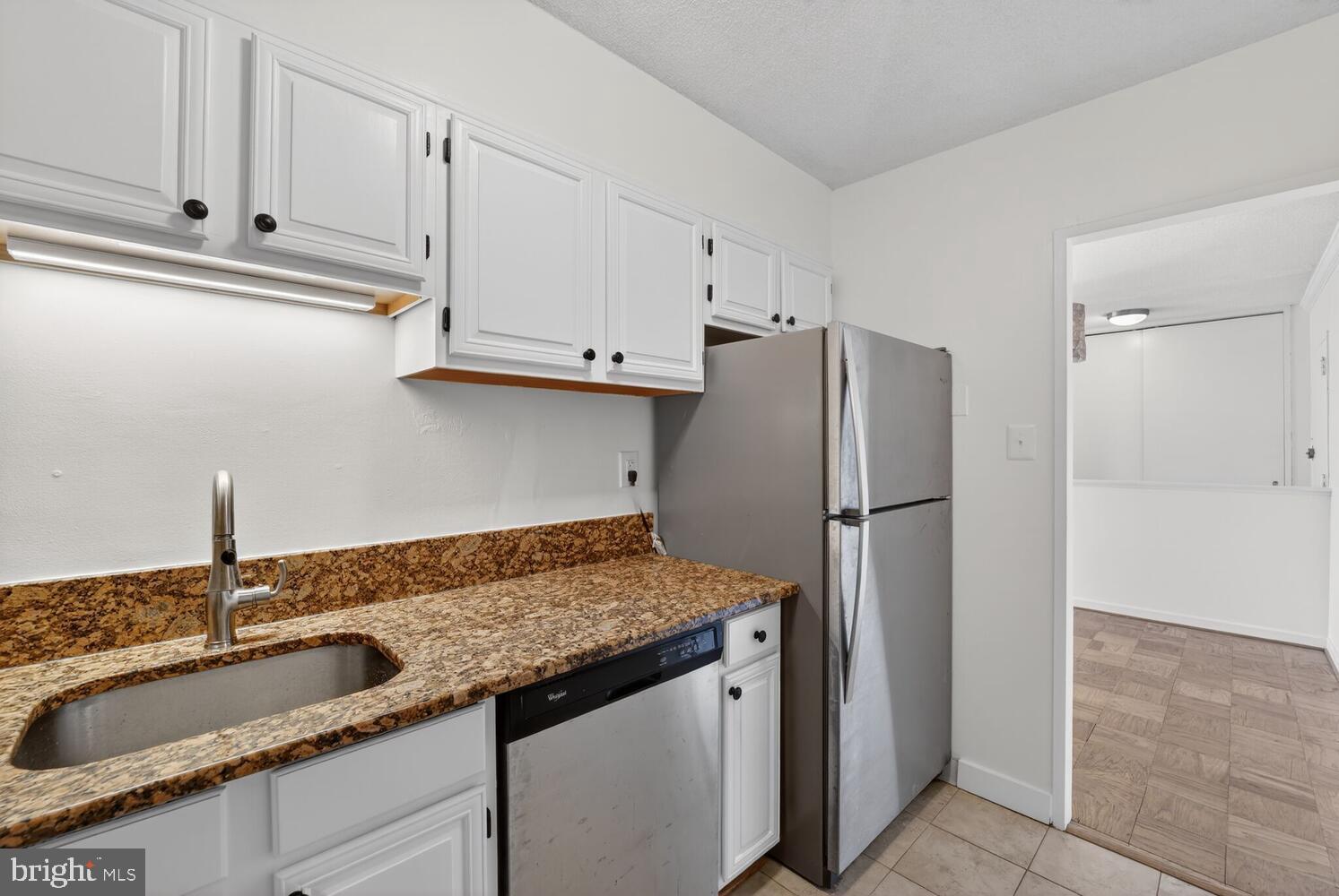 240 M Street Southwest, Unit E406 Washington, DC 20024 - Photo 13 of 38 a kitchen with granite countertop a refrigerator and a sink