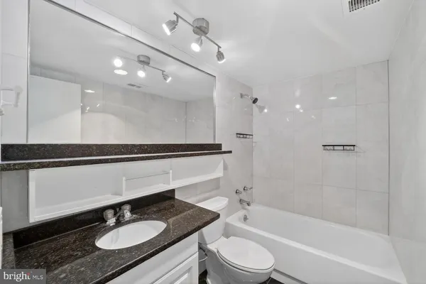 a kitchen with granite countertop a refrigerator and a sink