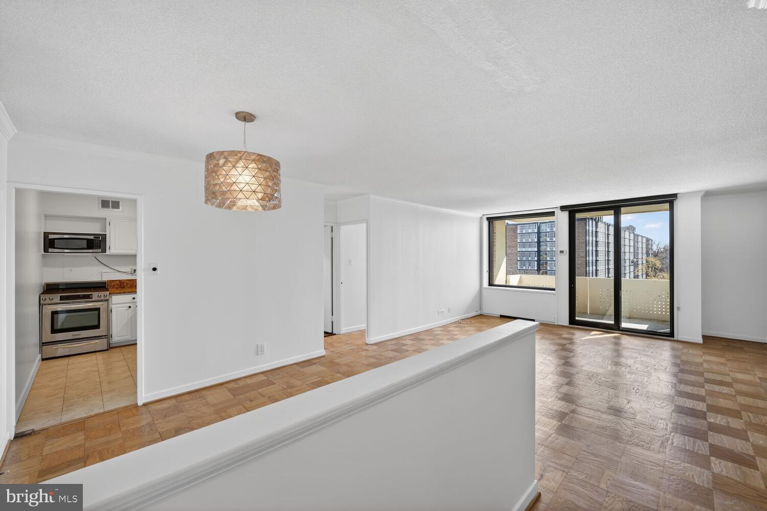 240 M Street Southwest, Unit E406 Washington, DC 20024 - Photo 4 of 38 a view of an empty room with window and wooden floor