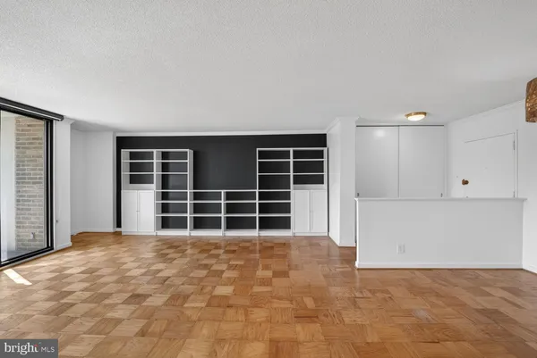 a view of wooden floor in an empty room with a window