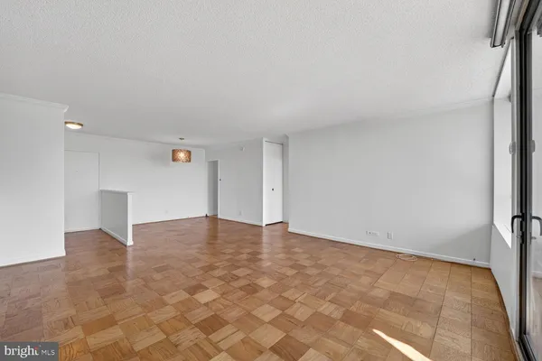a view of an empty room with wooden floor