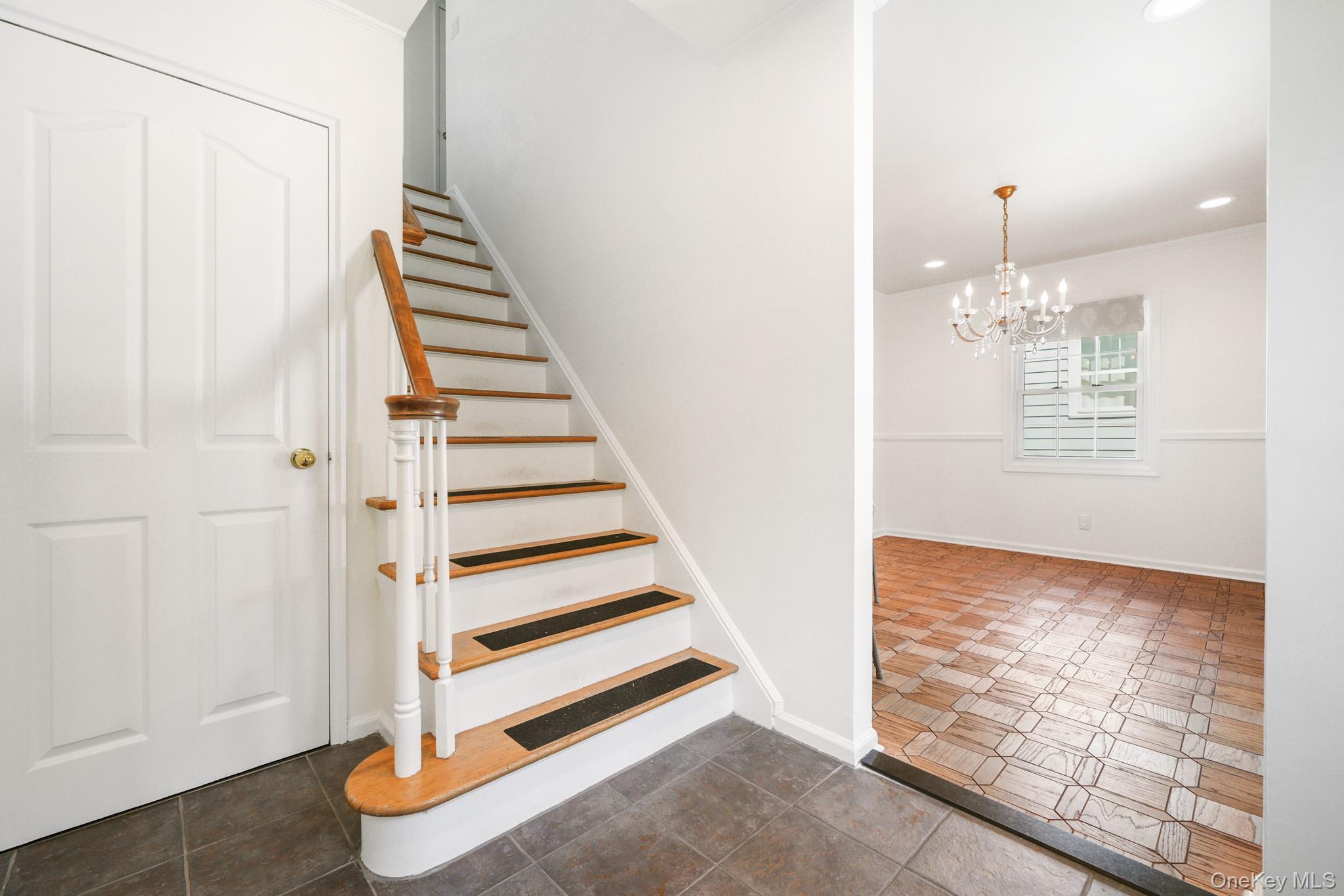 29 Chatfield Road Bronxville, NY 10708 - Photo 3 of 27 Stairs with recessed lighting, a chandelier, tile patterned floors, and crown molding