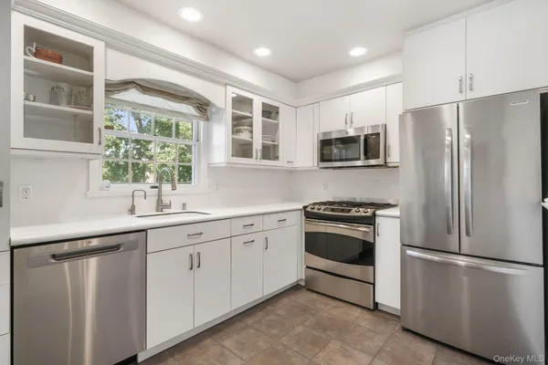 a kitchen with stainless steel appliances a refrigerator sink and microwave