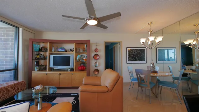 a living room with furniture a chandelier and a flat screen tv