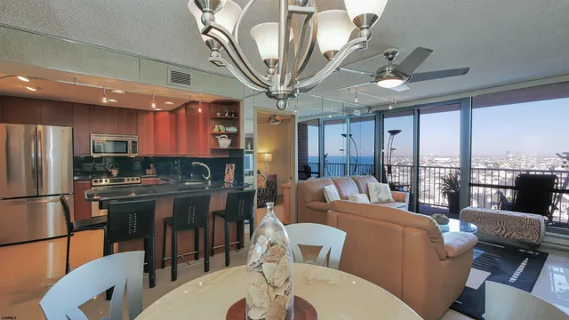 a living room with furniture a large window and stainless steel appliances