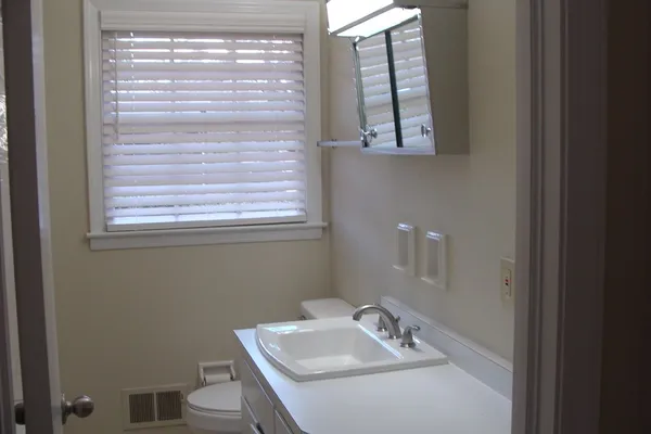 a bathroom with a sink a toilet and a window