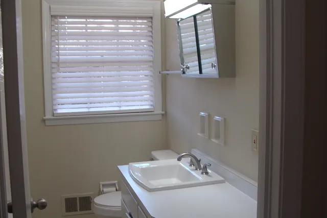a bathroom with a sink a toilet and a window