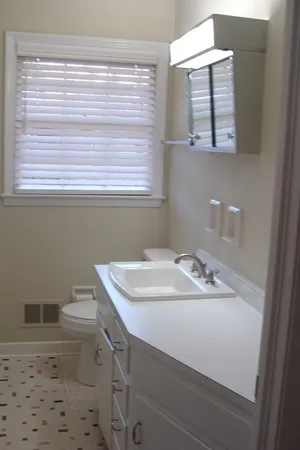 a bathroom with a sink a toilet and a window