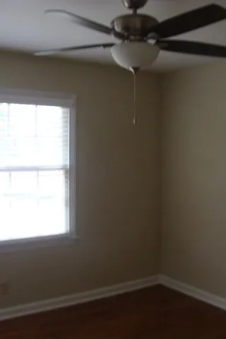 a view of a small space with wooden floor and a window