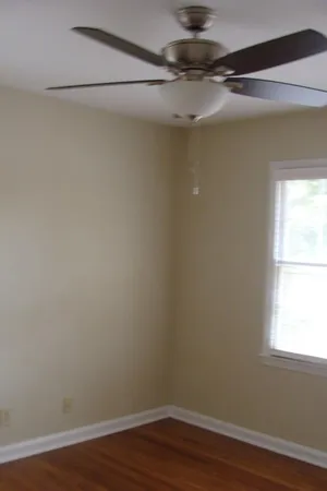 a view of a small space with wooden floor and a window