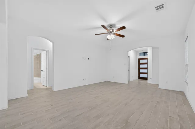 an empty room with a empty space and a ceiling fan