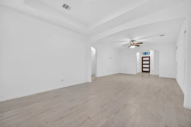 a view of a big room with wooden floor and windows