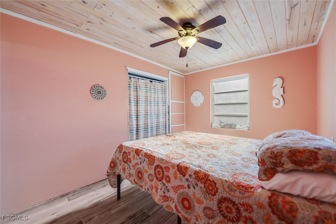11494 May Street Matlacha, FL 33993 - Photo 21 of 45 a bedroom with a large bed chandelier and a window