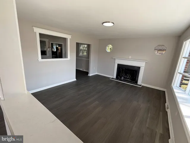 a view of an empty room with window and fire place